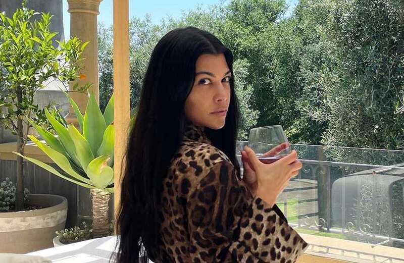 Kourtney shows off real skin & natural curves while posing in just leopard robe