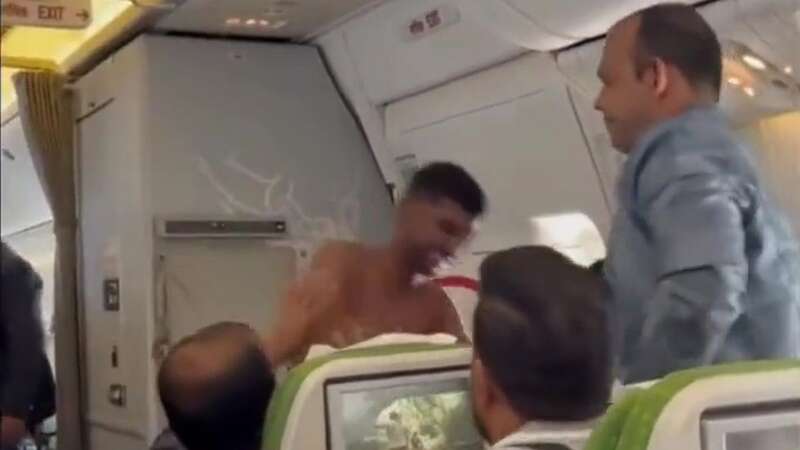 Topless thug brawls with another passenger on packed plane in row over seats