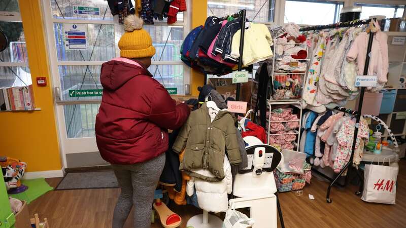 Tina browses a baby bank in Hackney for a winter coat (Image: Phil Harris)