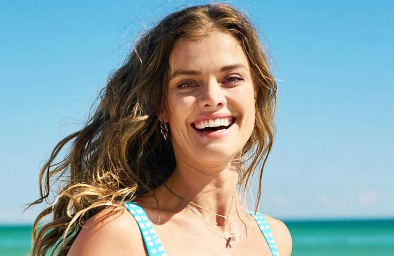 Nina Agdal stuns in tiny blue and white bikini as she runs along the beach