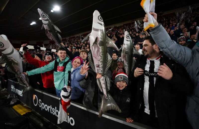 Why do Grimsby fans wave inflatable fish during FA Cup games?