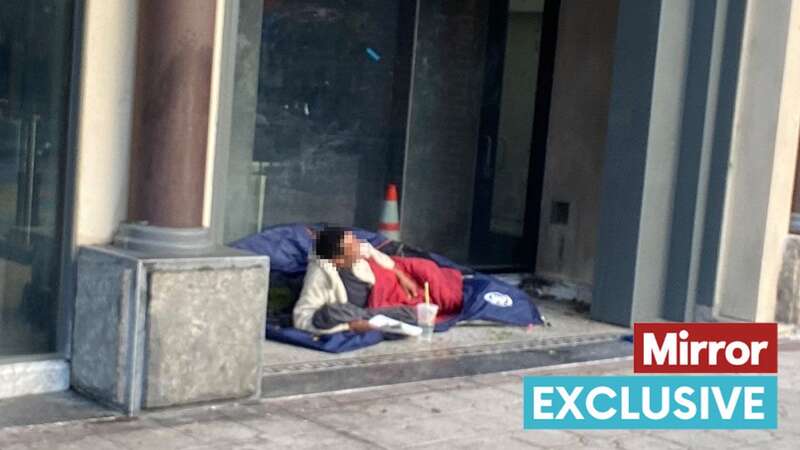 A man shelters under a billboard steps from the Dolby Theatre, where this year