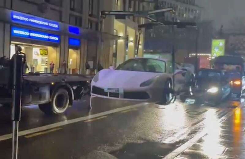 Stunned commuters watch pink Ferrari lifted out of bus lane and onto truck