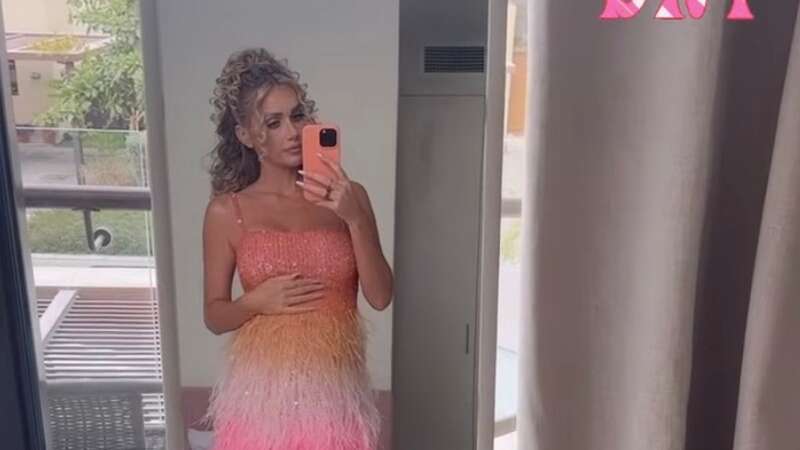 Pregnant Laura Anderson is seen cradling her bump in a colourful tassel dress (Image: Instagram)