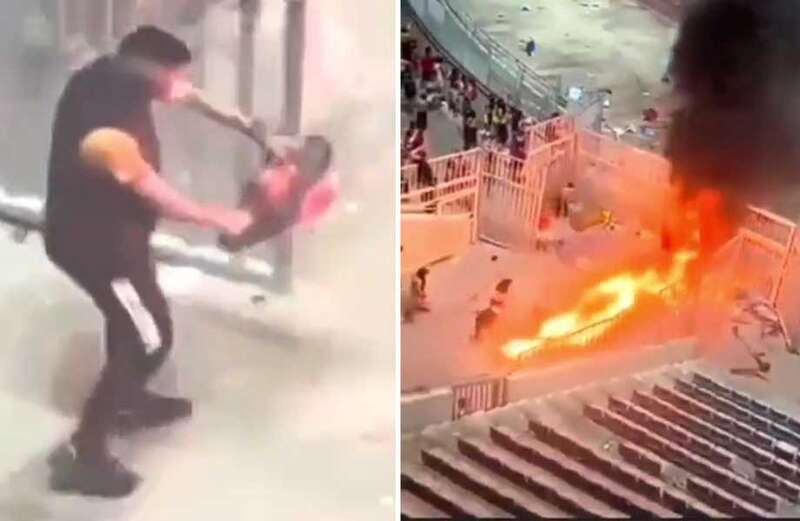 Fan strolls around stand with CHAINSAW as riots leave stadium in flames