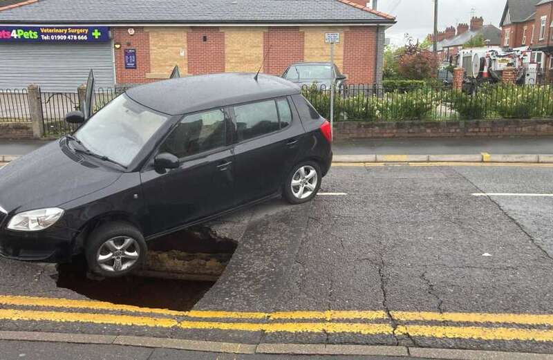 Terrifying moment car teeters on edge of sinkhole which opened suddenly in road