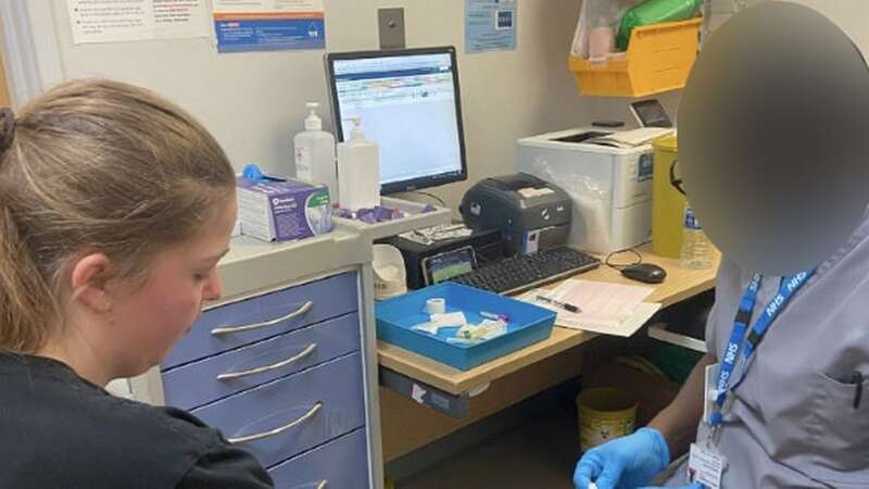 The nurse appears to be watching something on his phone (Image: Nicola Bates / SWNS)