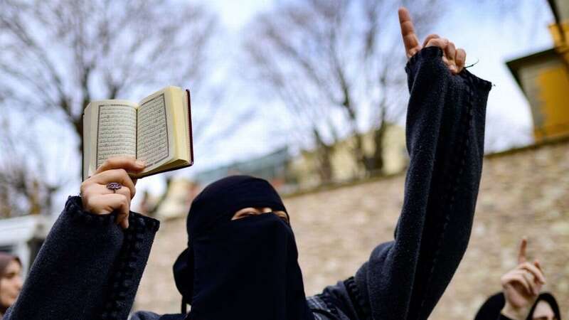 A woman holds a Quran during protests against a right-wing attack in Sweden last year (Image: AFP via Getty Images)