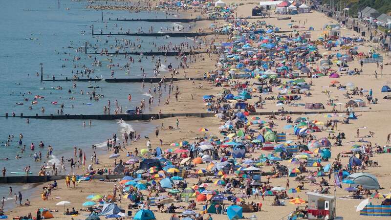 People gather in scorching weather on a beach in Dorset (Image: PA)