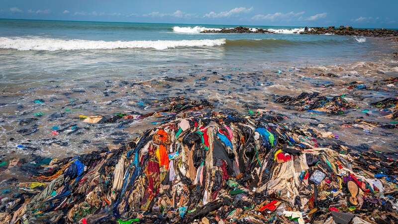 Mound of discarded clothes washed up on beach in Ghana (Image: Adam Gerrard / Daily Mirror)