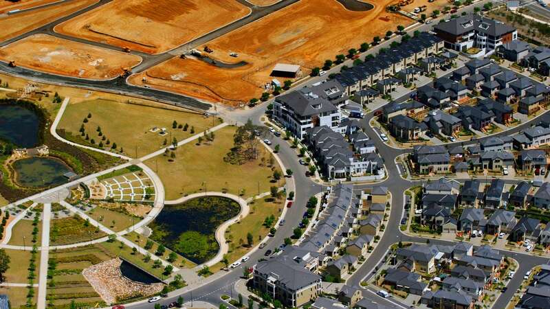 A sea of grey roofs and landscaping of a new housing development under construction in Western Sydney