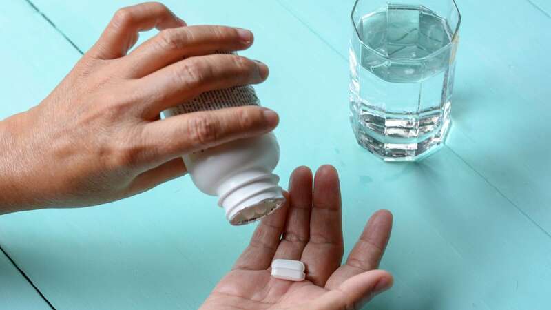 A woman pours tablets in her hand (Image: Getty Images)