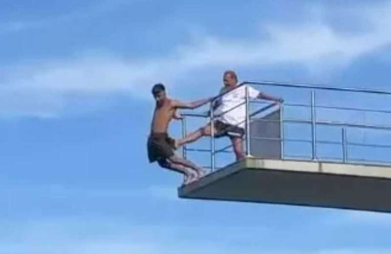 Shocking moment lifeguard boots nervous swimmer off 10m high diving board