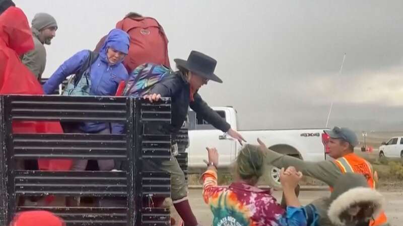 Festival goers are helped off a truck from the Burning Man festival site in Black Rock, Nevada (Image: AP)