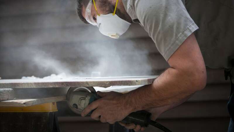 Latino immigrants work on heavy slabs of engineered stone, producing countertops in Pacoima (stock pic) (Image: Getty Images)