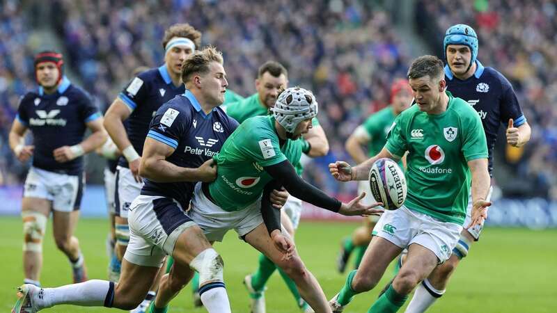 Mack Hansen offloads to Johnny Sexton whilst being tackled by Duhan van der Merwe during Ireland