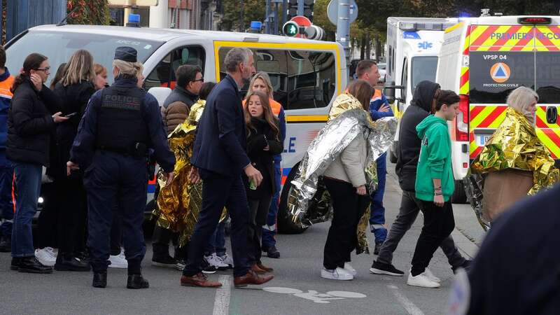 Police officers and rescue workers escort children outside the high school after a bomb alert yesterday (Image: AP)