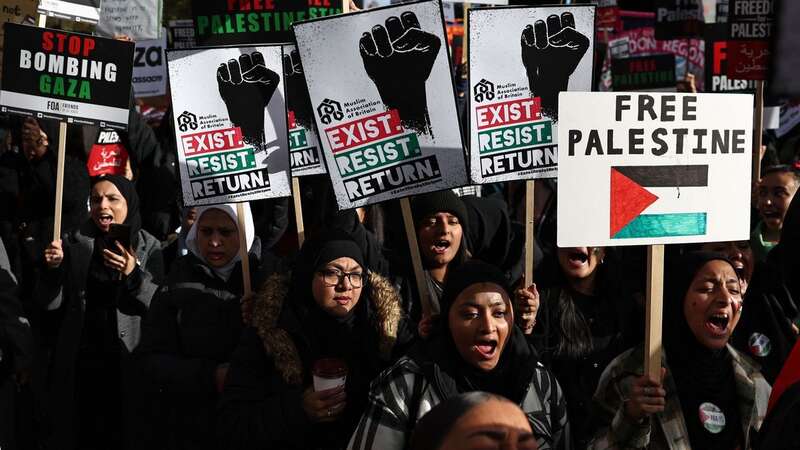 People hold up placards as they gather to take part in a 