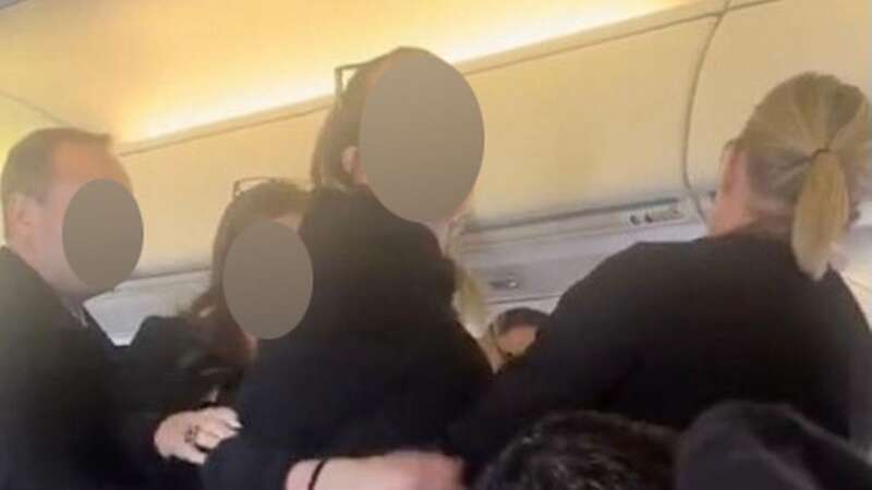 A woman was caught on video shoving flight attendants and screaming, "I