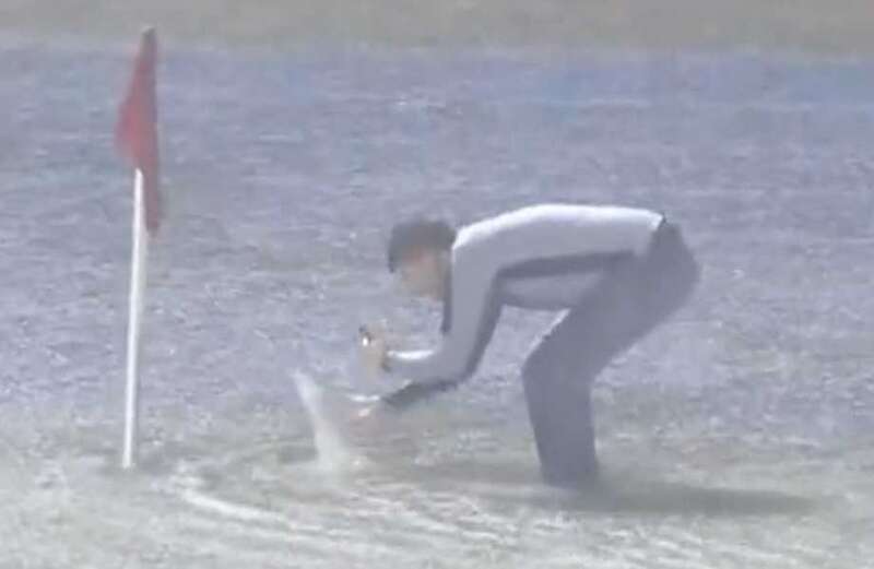 Officials took to the pitch to inspect it... despite parts of it being underwater