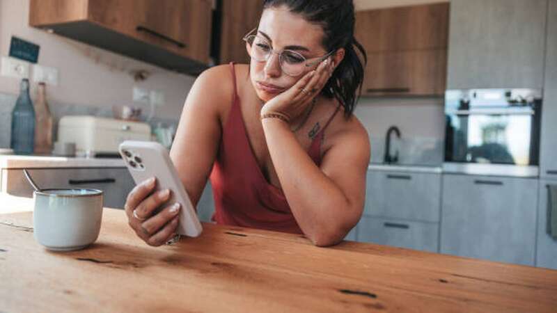 Worried woman checking phone. Picture posed by model