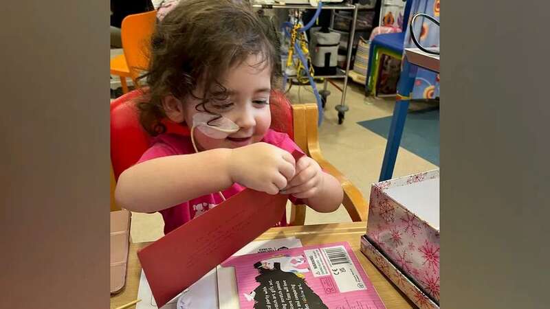 Evie excitedly opens a Christmas card