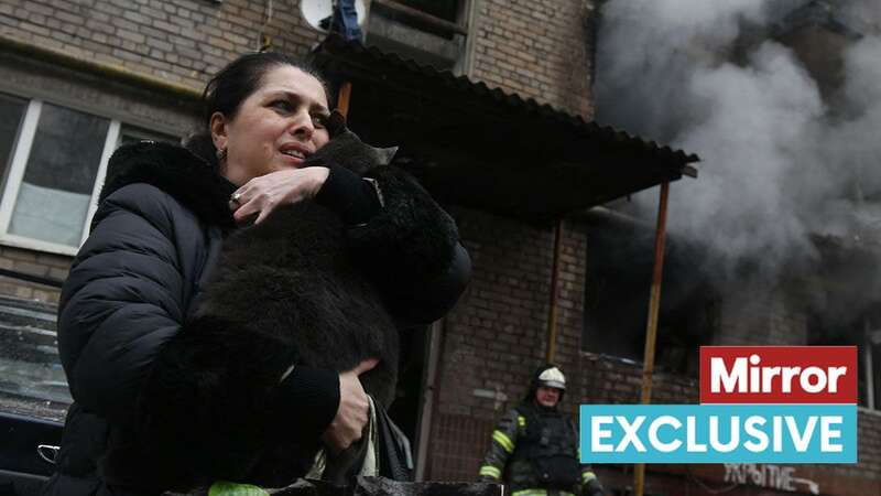 A woman holds on to her cat, which was rescued by firefighters after the shelling of a residential building in Donetsk (Image: AFP via Getty Images)