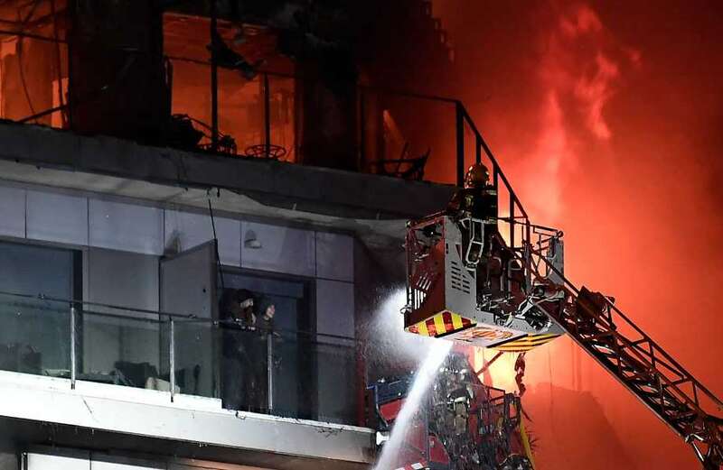 Shocking footage shows people trapped on balconies screaming for help as flaming chunks fall from the building