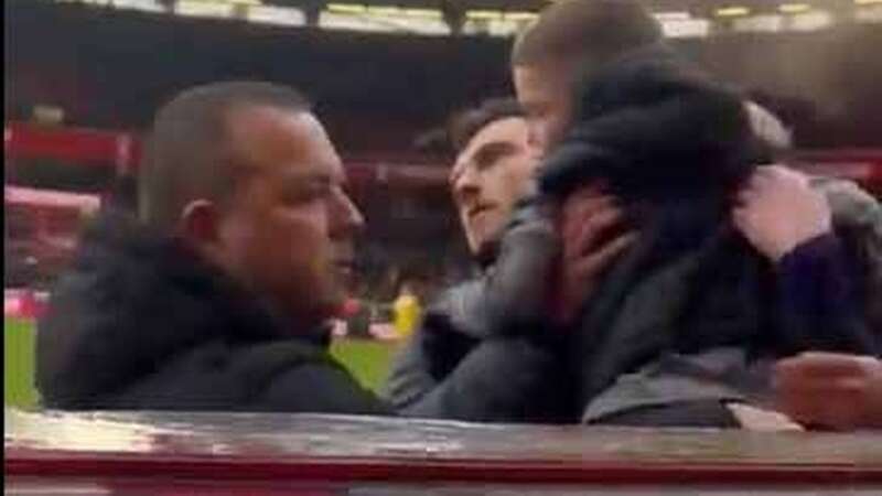 Andy Robertson lifts the young Liverpool fan on to the pitch and away from Nottingham Forest supporters. (Image: x.com)