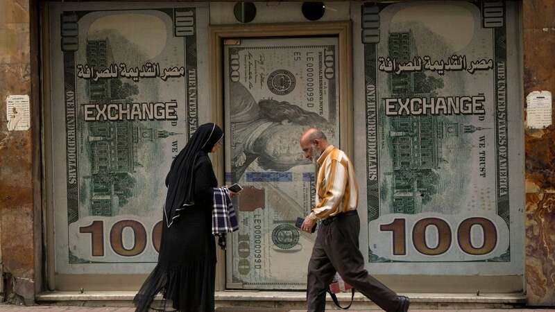 Egyptians walk past an exchange office in Cairo, Egypt, Wednesday, March 6 (Image: Copyright 2024 The Associated Press. All rights reserved)