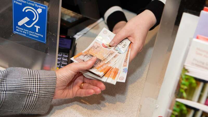 A customer withdraws cash at Bamford Post Office in Derbyshire (Image: PA Archive/PA Images)