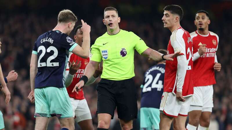 Brighton and Arsenal players are separated by referee Robert Jones