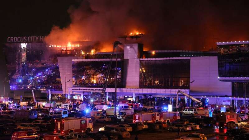 Emergency services vehicles are seen outside the burning Crocus City Hall concert hall following the shooting incident (Image: AFP via Getty Images)