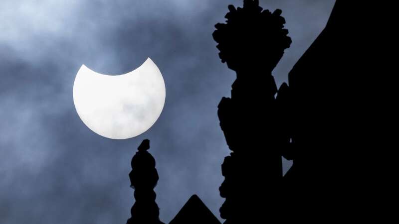 A partial solar eclipse is seen over the Houses of Parliament on June 10, 2021 (Image: Getty Images)