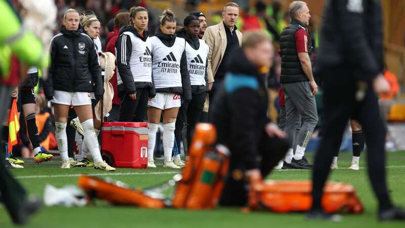 Players of Arsenal and Jonas Eidevall, Manager of Arsenal, look on as Frida Maanum of Arsenal (not pictured) receives medical treatment