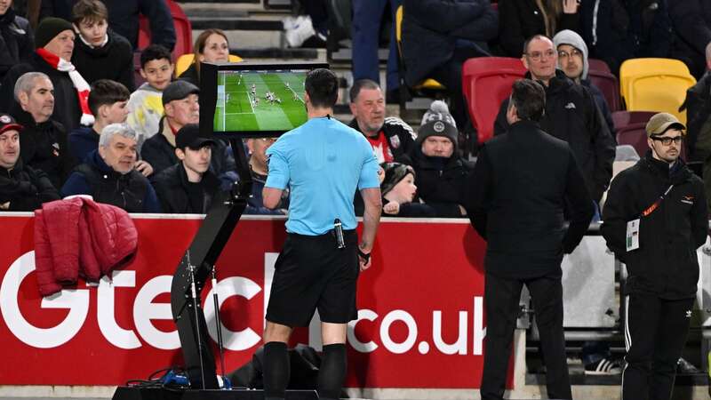 Andrew Madley looks at the VAR monitor before deciding against awarding Brighton a penalty against Brentford.