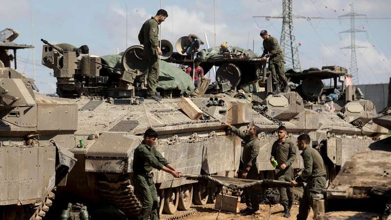 Israeli soldiers prepare their equipment and armored personnel carriers (Image: Getty Images)