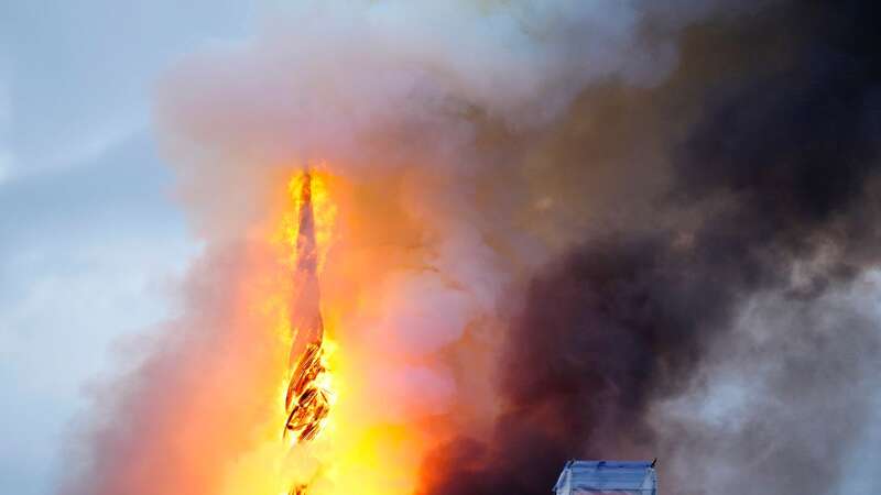 Terrifying moment spire topples as 400-year-old building engulfed in flames