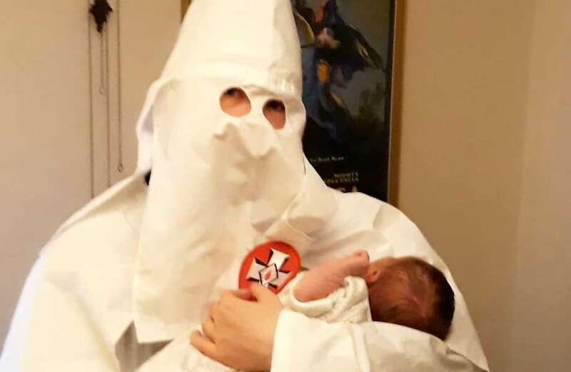 Thomas posed in a Ku Klux Klan robe with his child