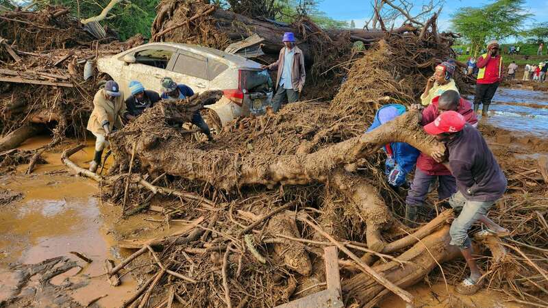 People trying to clear the area after a dam burst in Kenya