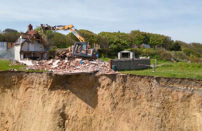 Pictures reveal state of farmhouse as workers move in to pull it down