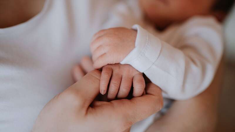 A young woman with her new baby in arms (file image) (Image: Getty Images)