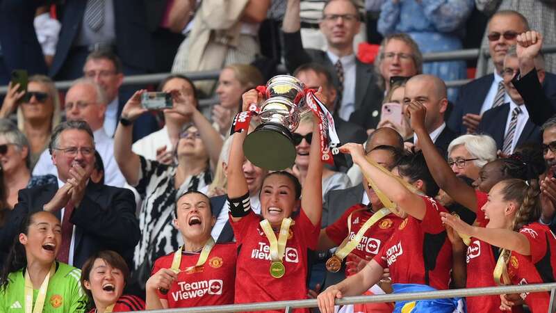 Katie Zelem lifts the FA Cup trophy after Manchester United Women