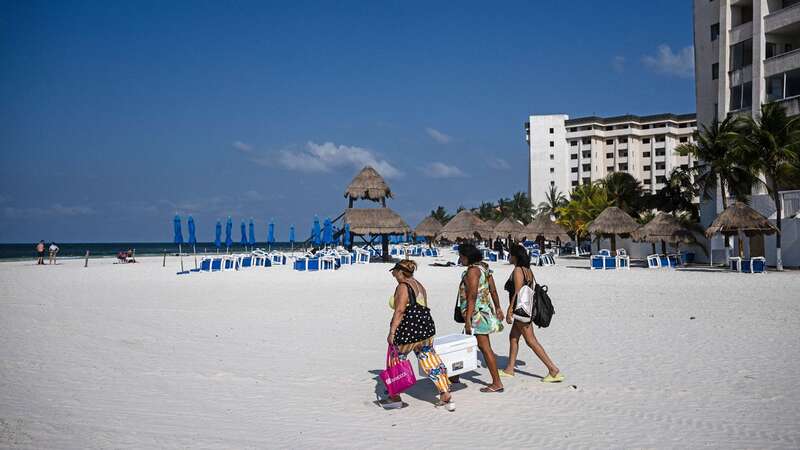 Beachgoers at Cancun in Mexico, where the government has issued warnings to UK tourists over violent crime rates (Image: AFP via Getty Images)