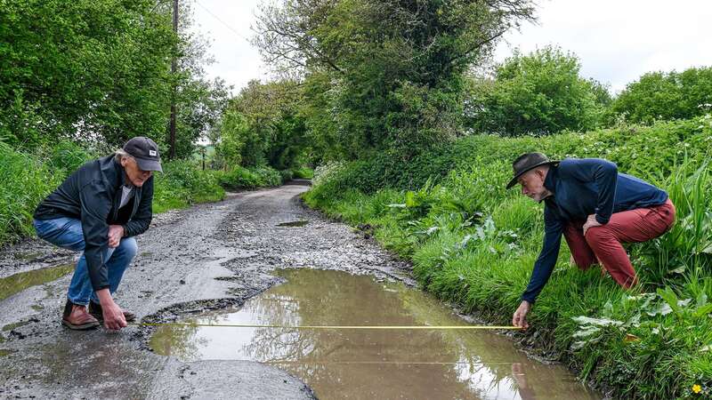 David Bennet and Vince Jenkins show the scale of the pothole (Image: Andrew Croft/Solent News)