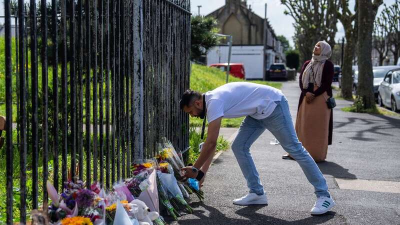 A man lays flowers after the five-year-old boy