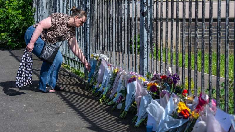 A woman lays flowers after a 5-year-old boy fell to his death from the upper floor of a block of flats, on May 17 (Image: Getty Images)