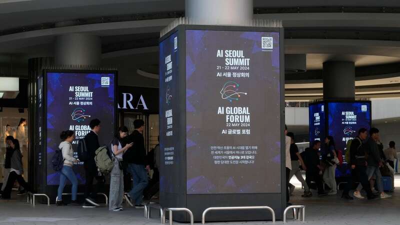 People pass by screens announcing the upcoming AI Seoul Summit in Seoul, South Korea (Image: Copyright 2024 The Associated Press. All rights reserved.)