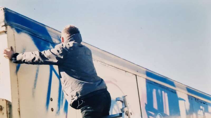 An artist believed to be Banksy working on The Turbozone Truck in Malaga in 2000 (Image: SWNS)