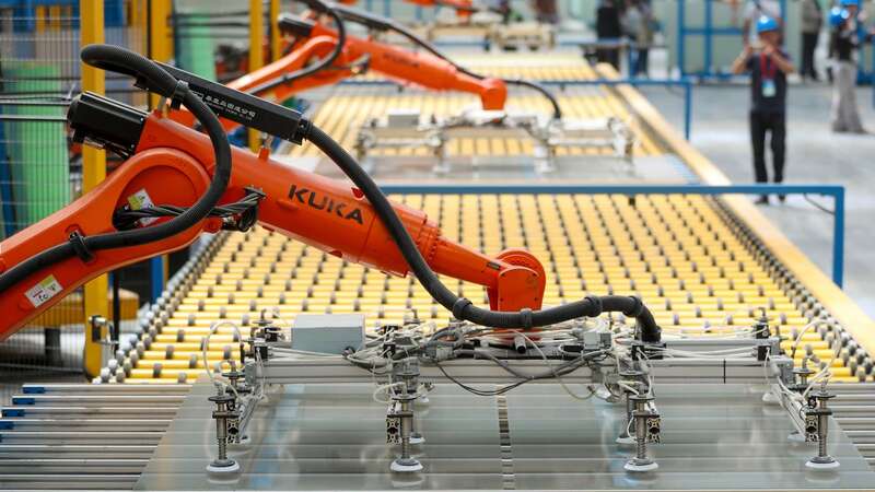 Kuka robots work on the production line of flat glass for solar panels at a subsidiary plant of Hoshine Silicon Industry in China